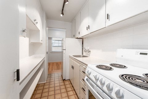 a white kitchen with a stove and a sink